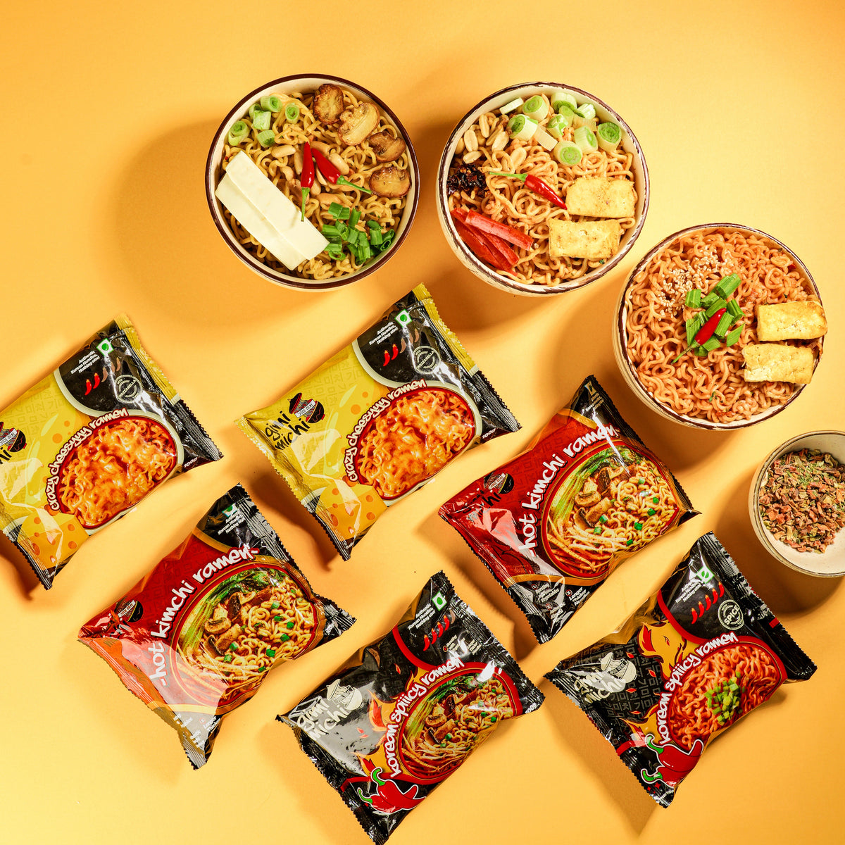 Gimi Michi ramen packs and prepared bowls laid out on a warm yellow background